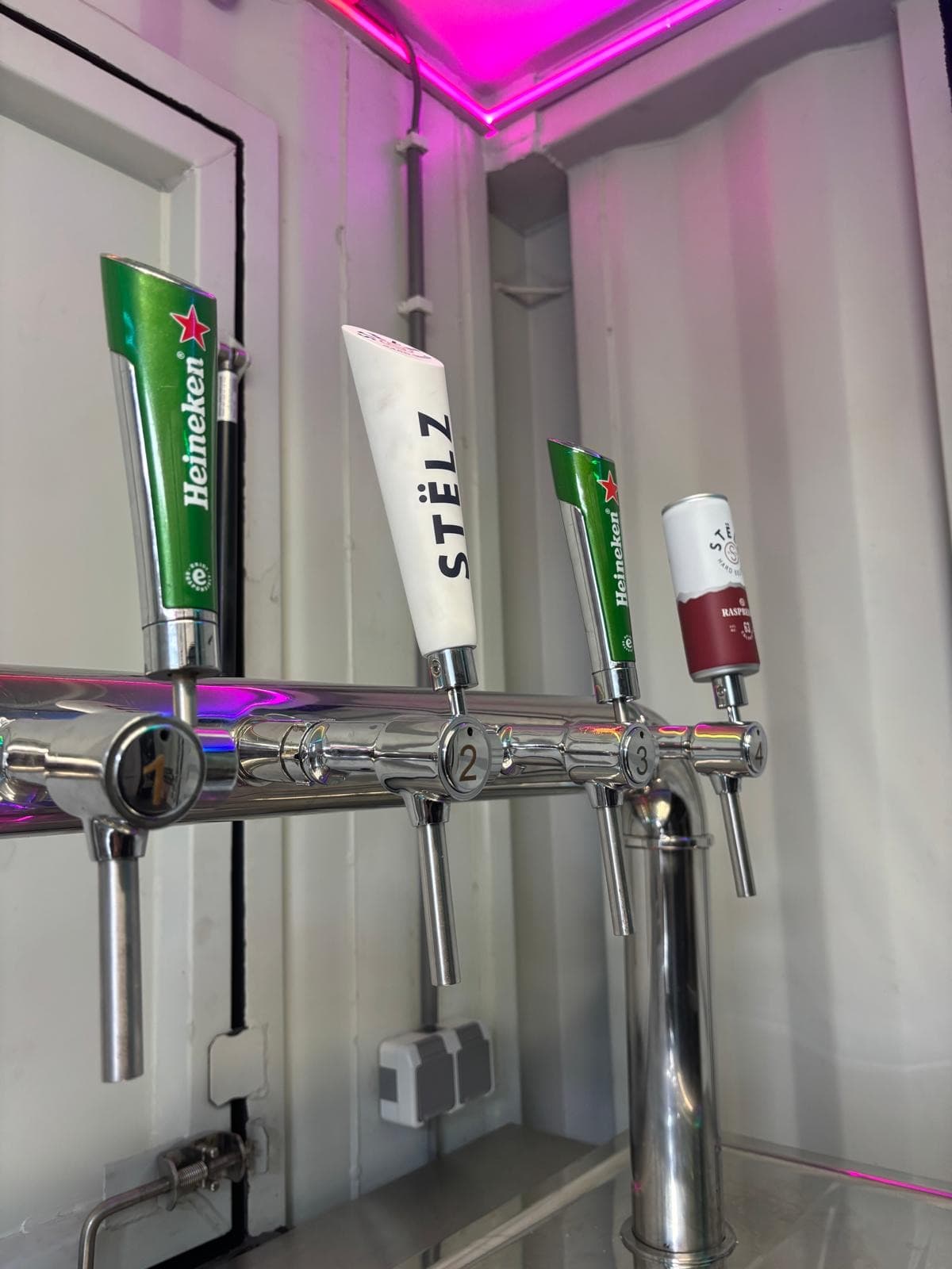 Vier tapkranen in de barcontainer met de LED-verlichting in kleur
