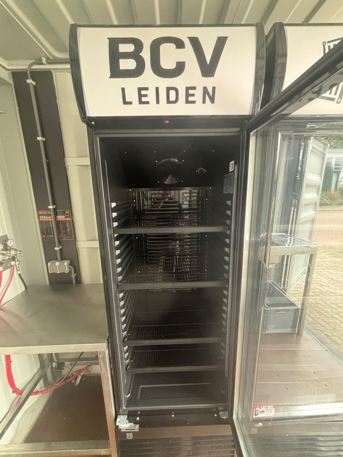 Koelkast in de barcontainer met verlicht BCV Leiden-paneel
